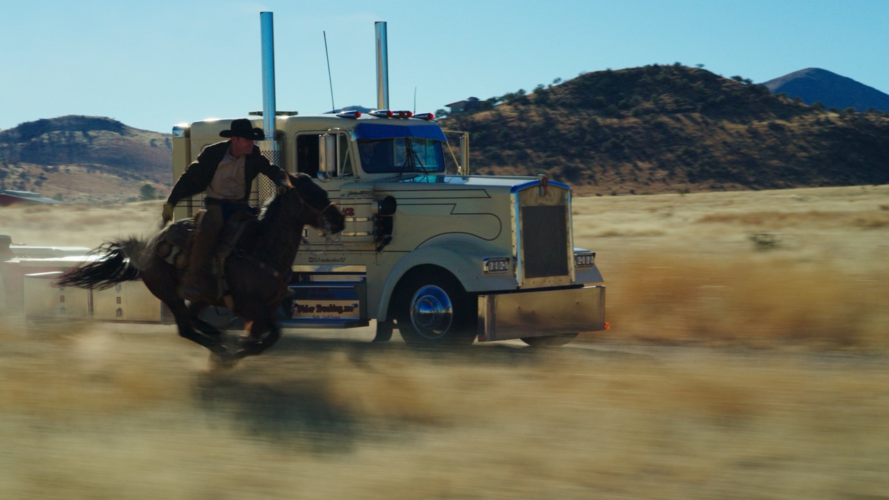 Cowboy galloping on horseback alongside a vintage semi truck across the grasslands near Marfa, Texas, from the Boot Barn Westward commercial